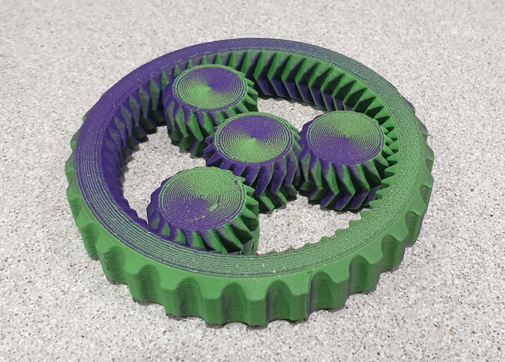 3D printed planetary gear spinner on a build plate, ready for use