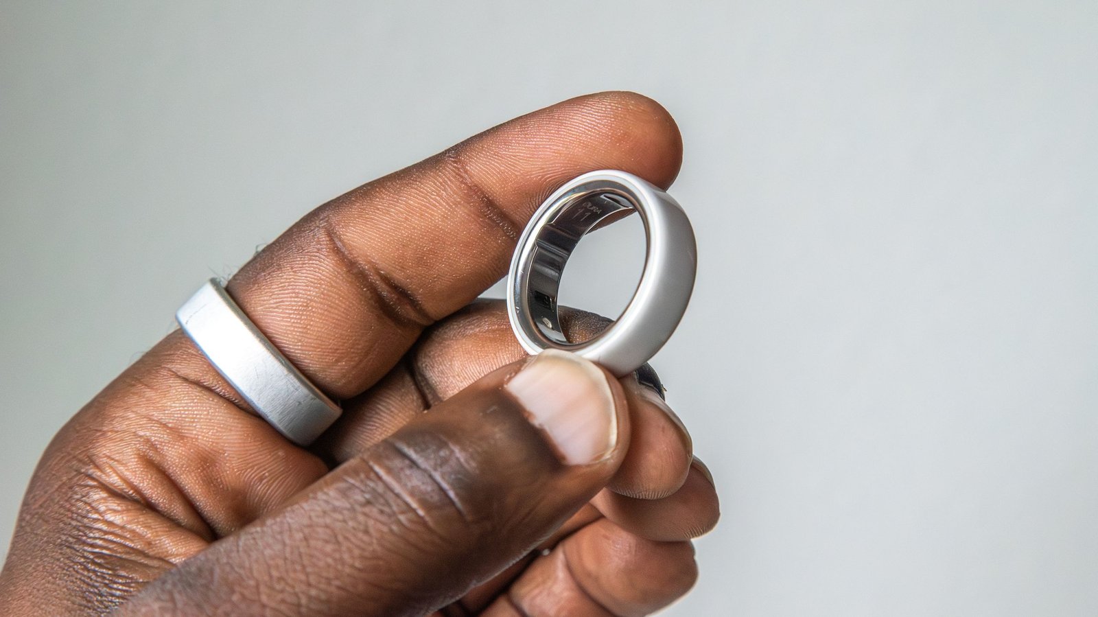 Oura Ring 4 on a person's finger, showcasing its sleek design and health tracking capabilities.