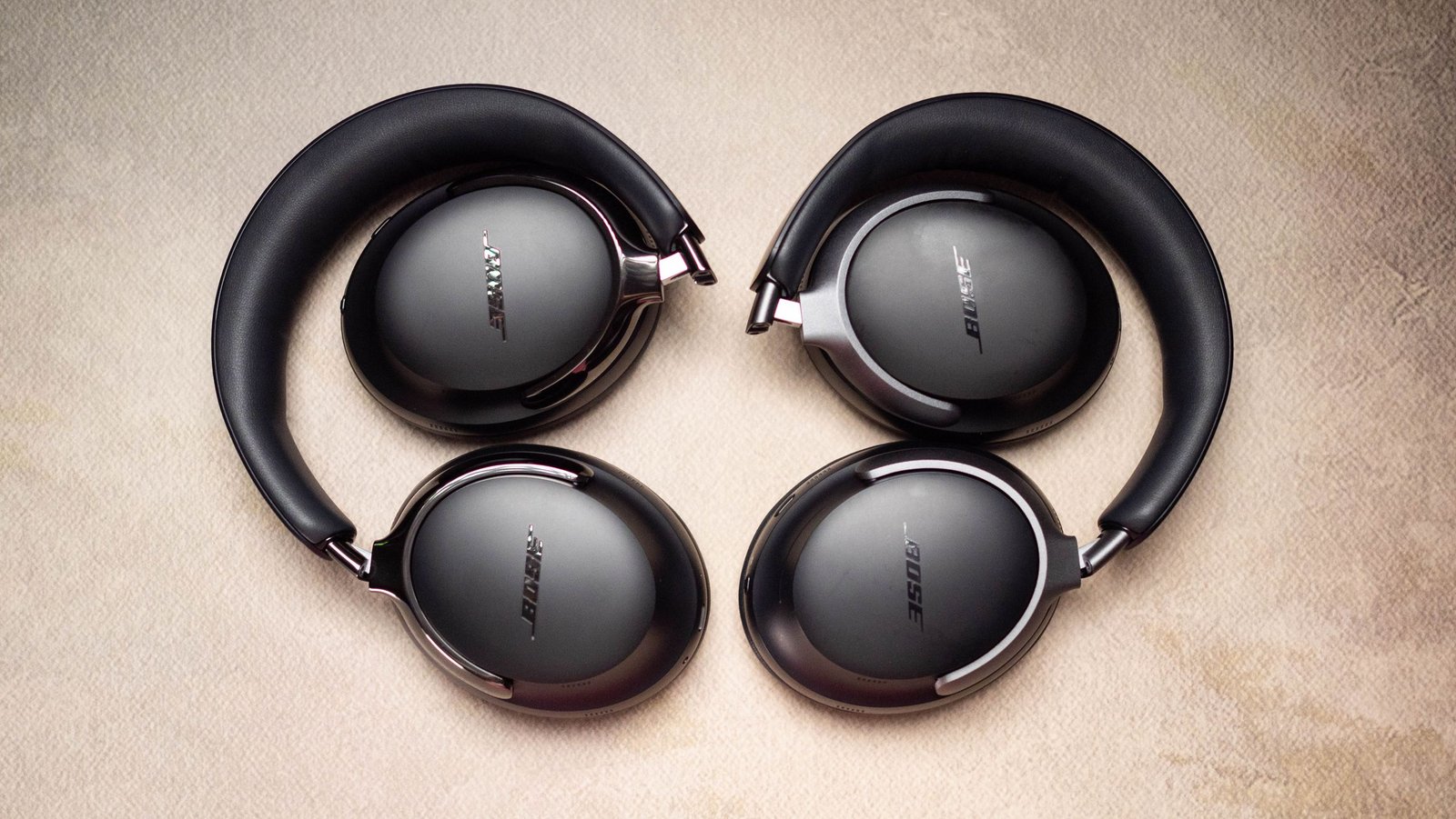 Bose QuietComfort Ultra headphones on a table with a passport and airplane ticket