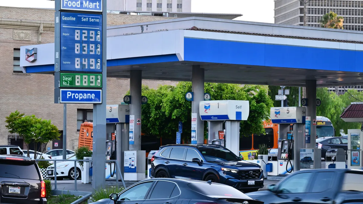 Gas station pumps with a digital display showing fluctuating fuel prices, symbolizing the AI fuel price fixing lawsuit in California.