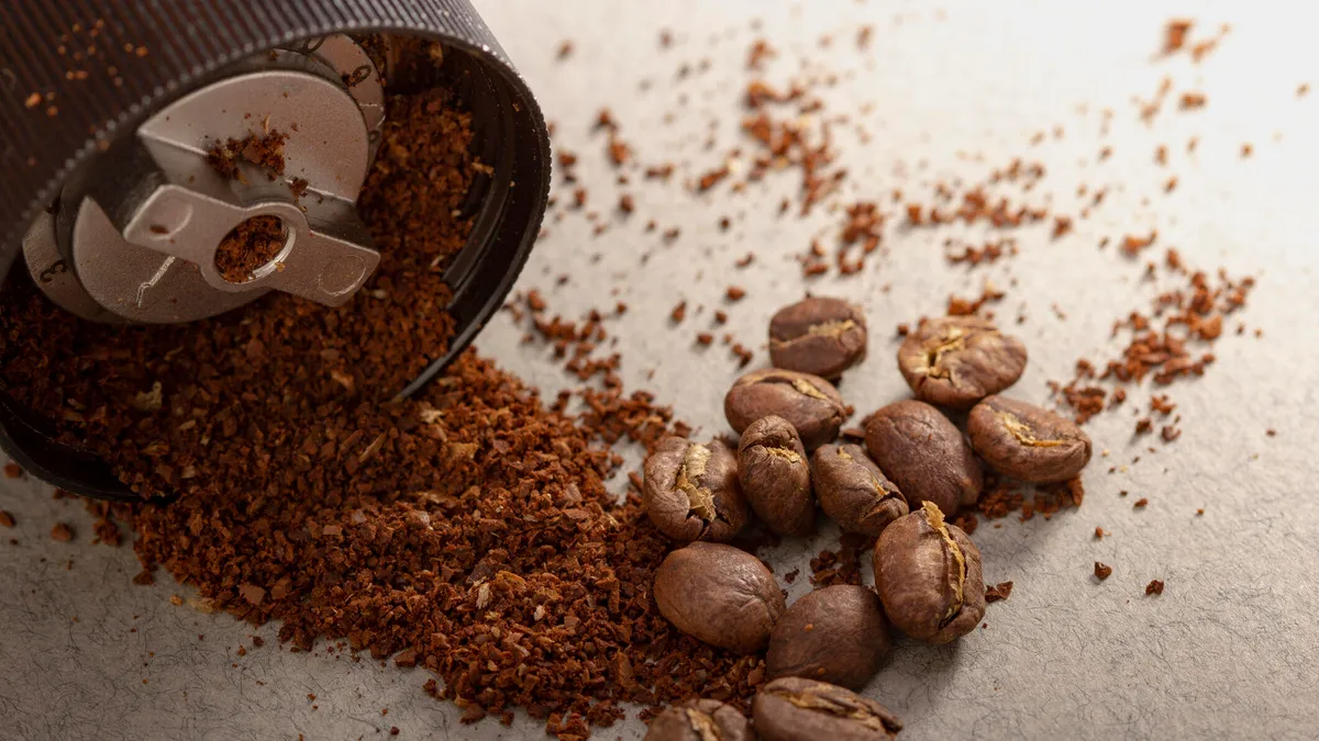 Close-up of a burr grinder with coffee beans