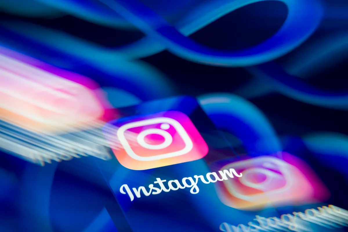 Person using a smartphone to adjust Instagram feed preferences, illustrating Instagram algorithm control.
