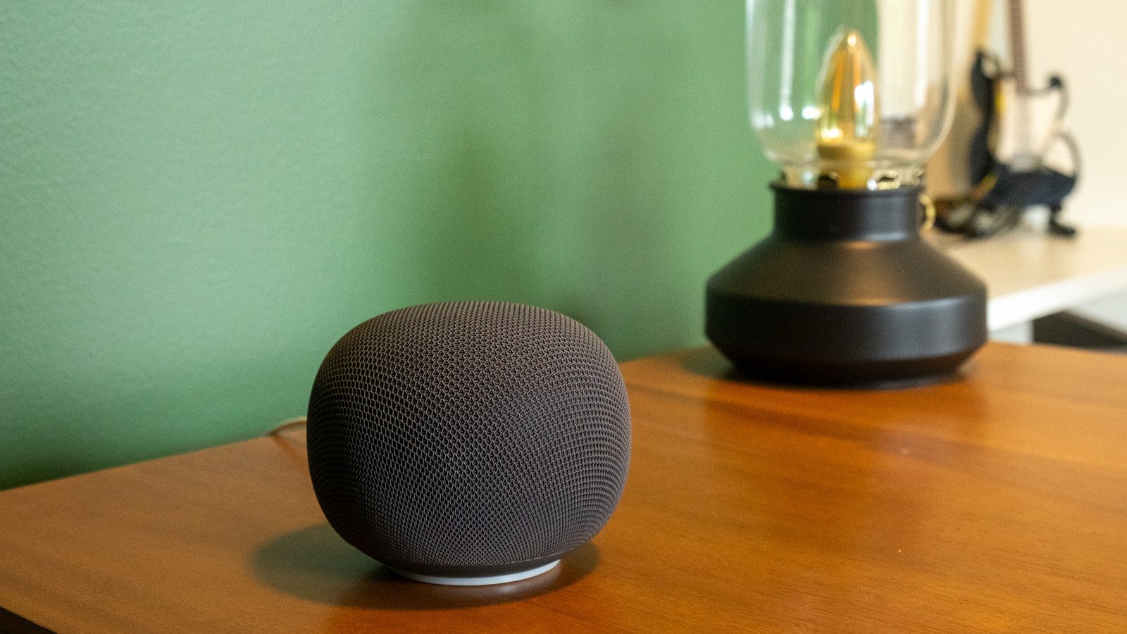 Google Home Speaker with Gemini interface displayed on a nearby phone screen